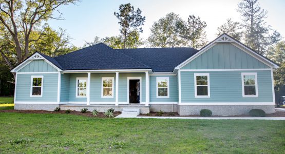 Front view of a brand new construction house with blue siding, a